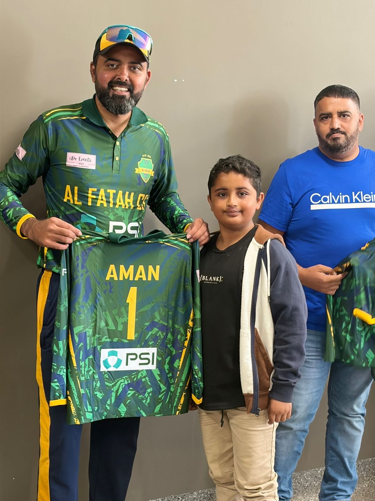 Faisal Hayat presenting an Al Fatah Cricket Club jersey to a junior player